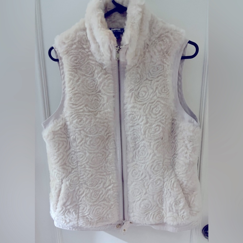 Classic white faux fur vest. Covered zippered front. Two slant pockets.
